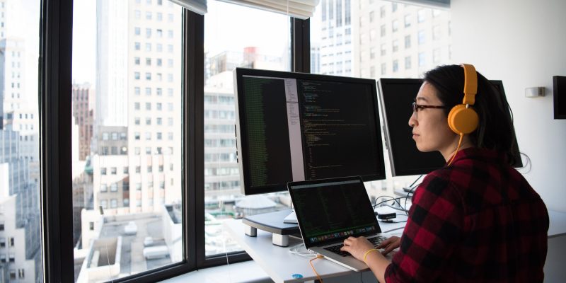 female programmer sitting in front of computer woman sitting while programming