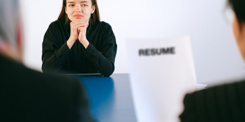 woman in black long sleeve shirt sitting having interview
