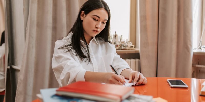 lady remote working Lady remote working writing on paper