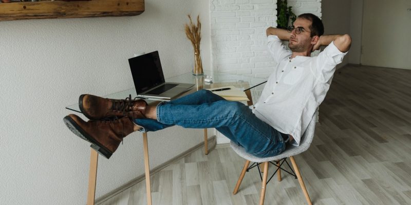 man making a 5-year career plan man in white dress shirt and blue denim jeans sitting on chair and planning career
