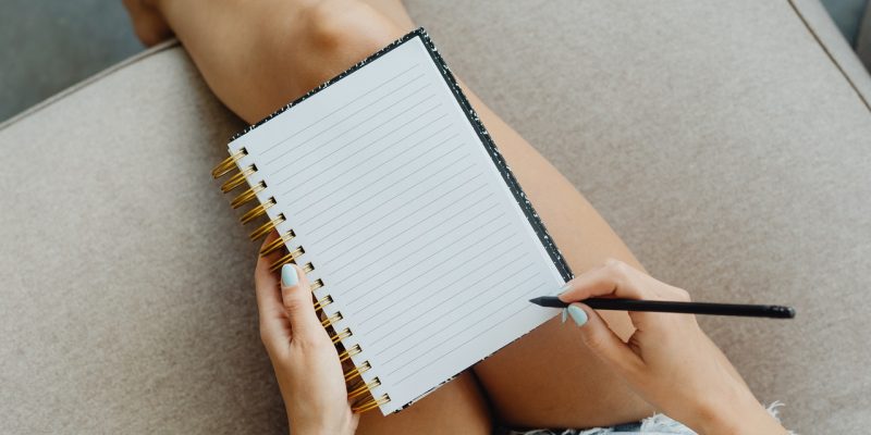 woman about to write on self care journal