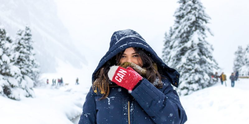 woman fighting winter blues woman in blue zip up hooded jacket standing in snow