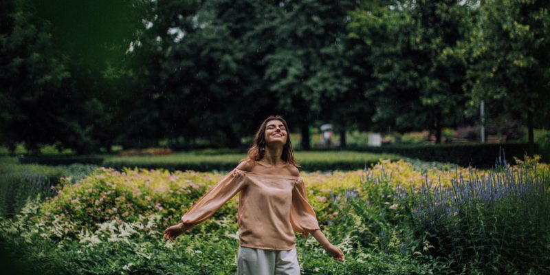 happy woman standing in a flower garden