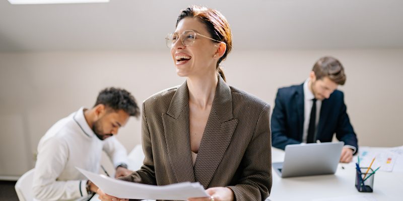 woman in brown blazer smiling in workplace