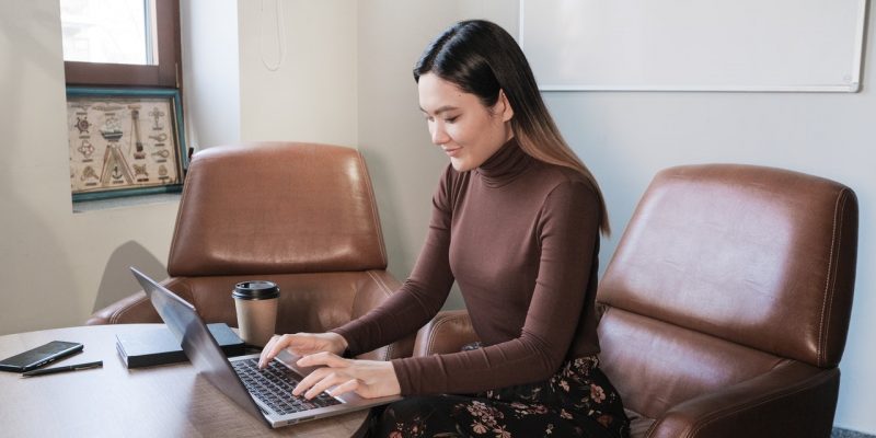 female job seeker typing resume on laptop