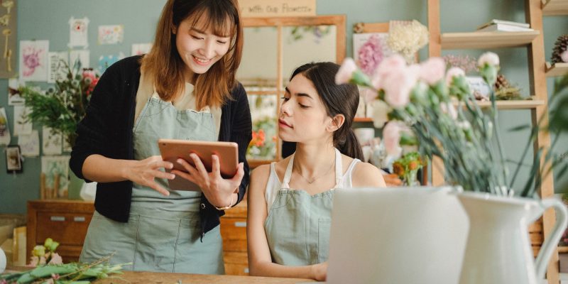 women creating a budget for small business two women with laptop in floral shop