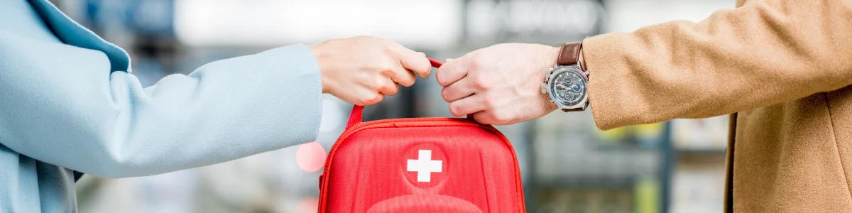 home-health-aide-handing-a-red-first-aid-bag-on-someone-wearing-a-watch