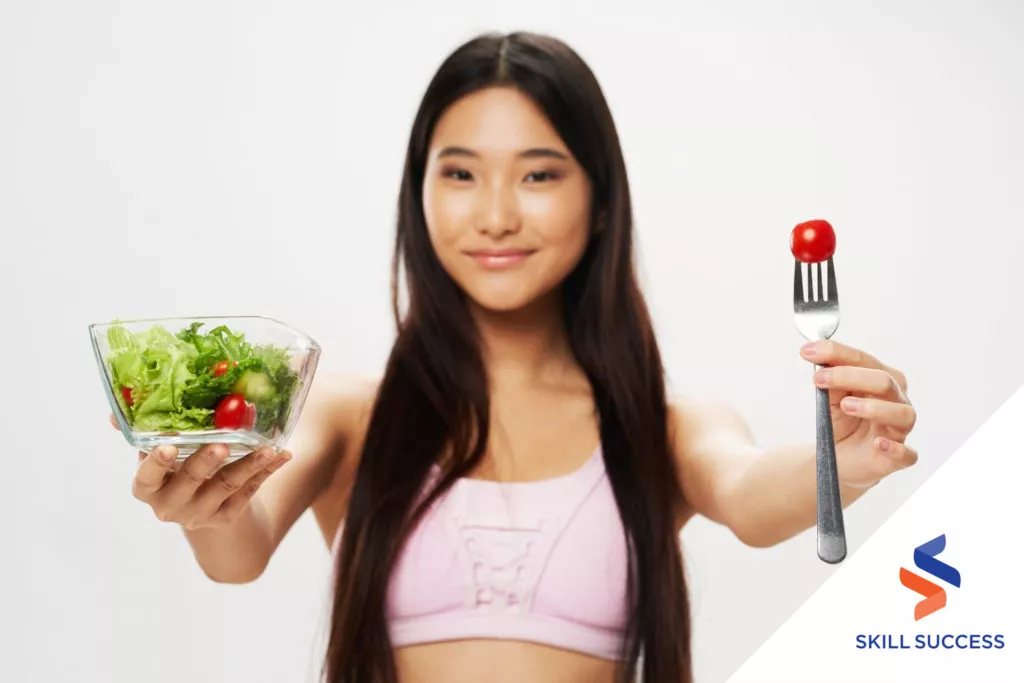 licensed-practical-and-licensed-vocational-nurse-holding-a-bowl-of-green-salad-and-a-fork-with-cherry-tomato