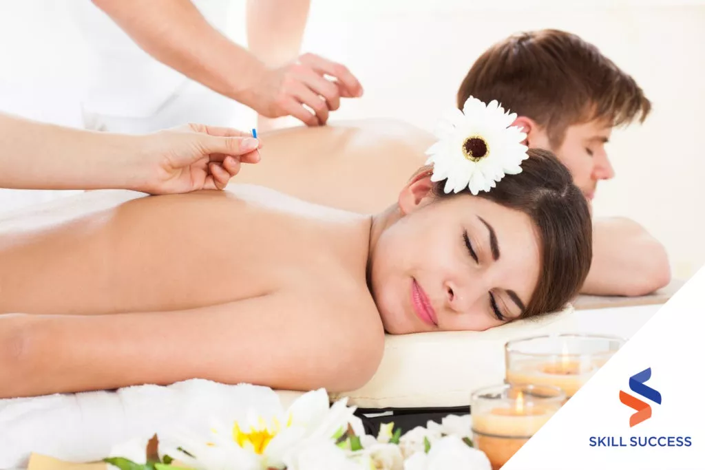 two-massage-therapists-perfomring-acupressure-to-a-couple