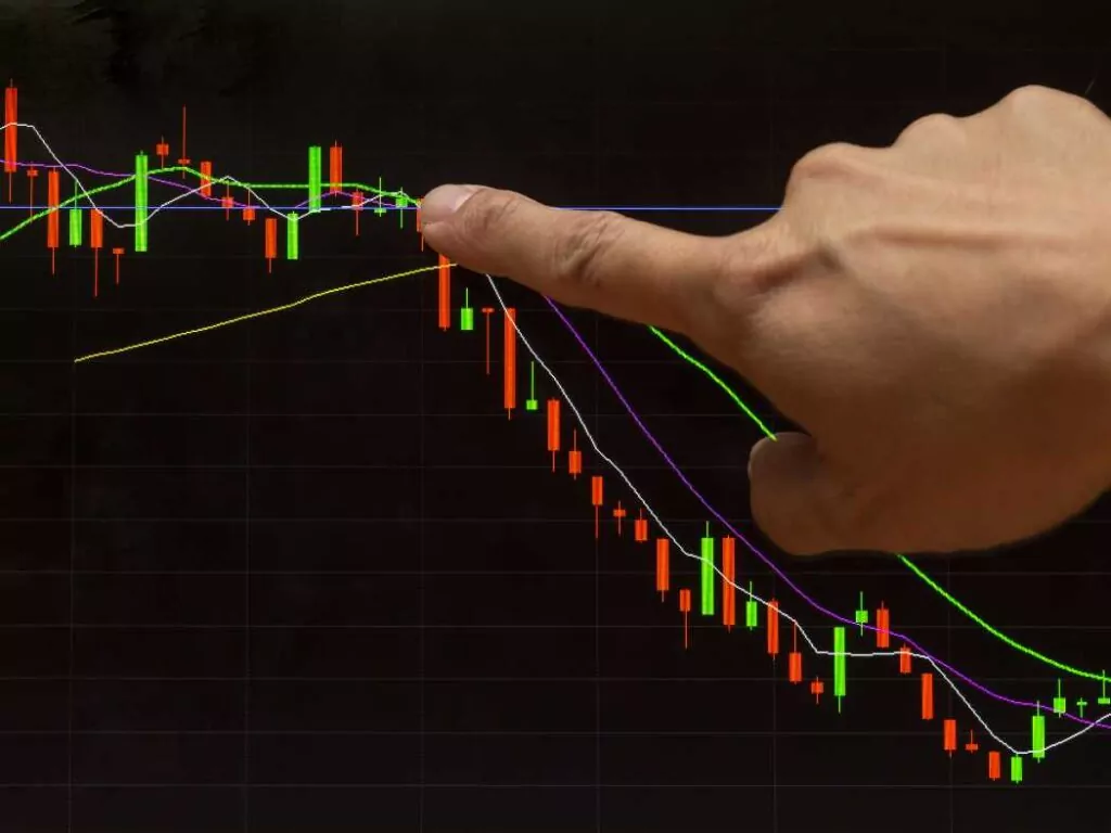 hammer candlestick chart hand pointing at chart