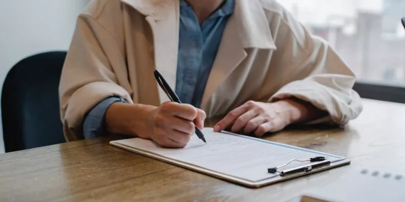 job applicant writing on clipboard during second interview